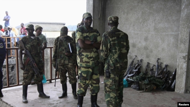 M23 rebels guard weapons given to them by the government's army in Goma November 21, 2012. 