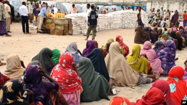 Internally displaced Somali women queue to receive food-aid rations at a distribution center