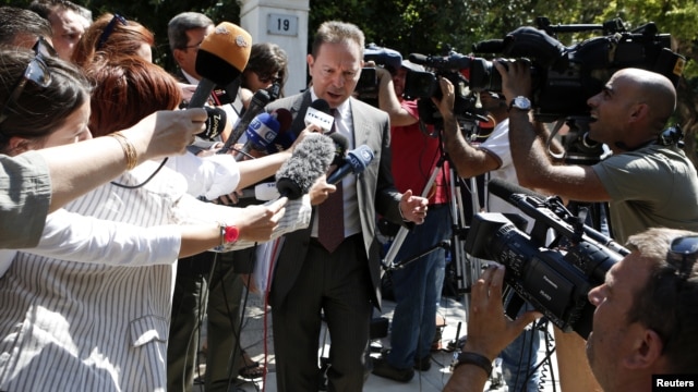 Greece's Finance Minister Yannis Stournaras is surrounded by the media as he leaves the Prime Minister's office in Athens, September 10, 2012.