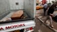 A woman walks past a truck carrying a wooden coffin of a man killed during an attack on liquor stores in Baghdad, Iraq, May 15, 2013. 