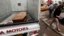 A woman walks past a truck carrying a wooden coffin of a man killed during an attack on liquor stores in Baghdad, Iraq, May 15, 2013. 