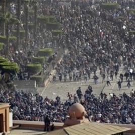 Pro-government demonstrators, below, clash with anti-government demonstrators, above, as an Egyptian Army soldier on the rooftop of the Egyptian Museum observes the scene in Tahrir square, in Cairo, February 02, 2011.
