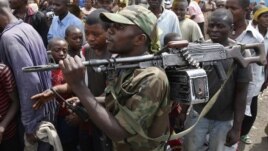 A M-23 rebel fighter walks with his rifle as the group withdraws from the eastern Congolese city of Goma, December 1, 2012.