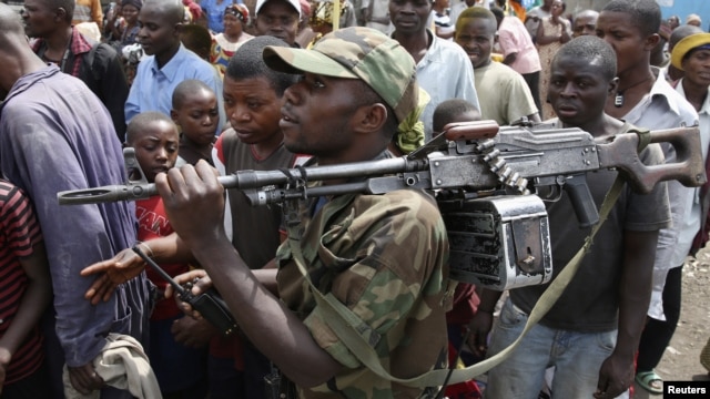 A M-23 rebel fighter walks with his rifle as they withdraw from Goma, December 1, 2012. 