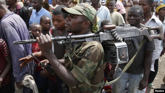 A M-23 rebel fighter walks with his rifle as the group withdraws from the eastern Congolese city of Goma, December 1, 2012.