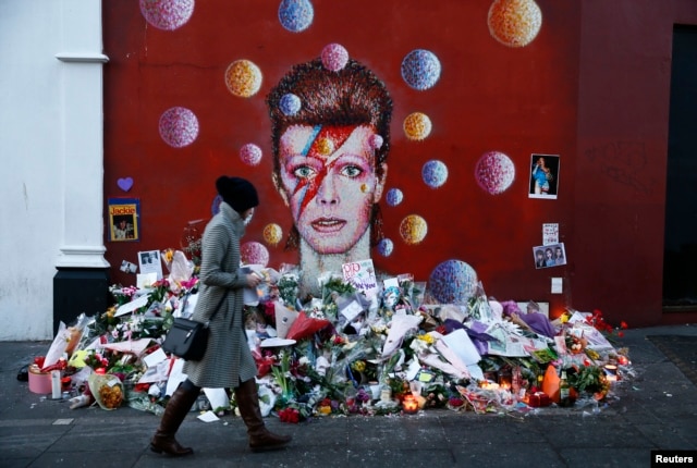 A woman looks at a mural of David Bowie in Brixton, south London, Britain, Jan. 12, 2016. Sales of David Bowie's last album - released two days before his death from cancer - have soared along with downloads of his greatest hits.