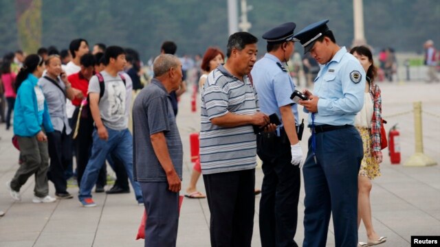 Nhân viên an ninh kiểm tra thẻ căn cước của du khách tại Quảng trường Thiên An Môn ở Bắc Kinh, ngày 4/6/2013. 