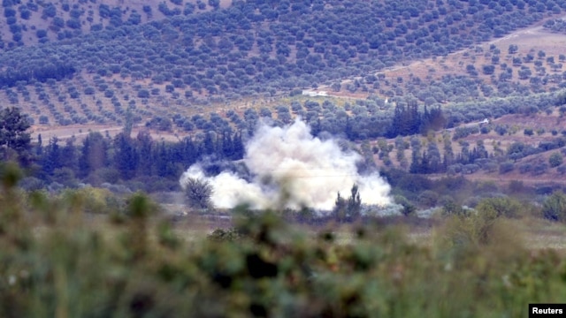 Smoke rises after a mortar bomb fired from Syria landed on Turkish soil on the Turkish-Syrian border in southern Hatay province, October 8, 2012.