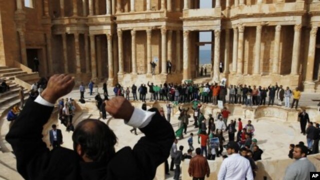 A man leads a chant by supporters of leader Moammar Gadhafi at a Roman amphitheatre in Sabratha, 75 km (46.6 miles) west of Tripoli, February 28, 2011
