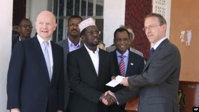 Somali President Sharif Sheik Ahmed, center, receives diplomatic credentials from British ambassador to Somalia Matt Baugh, right, and British Foreign Secretary William Hague, at Mogadishu's presidential palace, February 2, 2012.