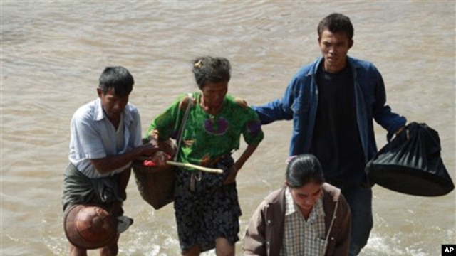 Burma citizens cross the Moei river as they flee Myawaddy township in Burma to Thailand's Mae Sot town, following fighting between Burma soldiers, ethnic Karen fighters, 08 Nov 2010