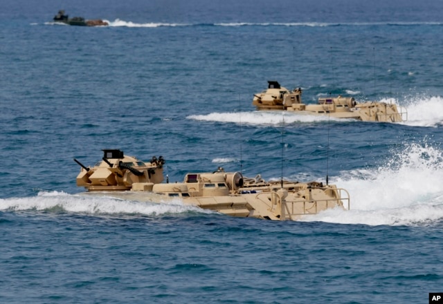FILE - U.S. Navy amphibious assault vehicles with Philippine and U.S. troops on board are seen during joint exercises near a beach facing one of the contested islands in the South China Sea known as the Scarborough Shoal in the West Philippine Sea.