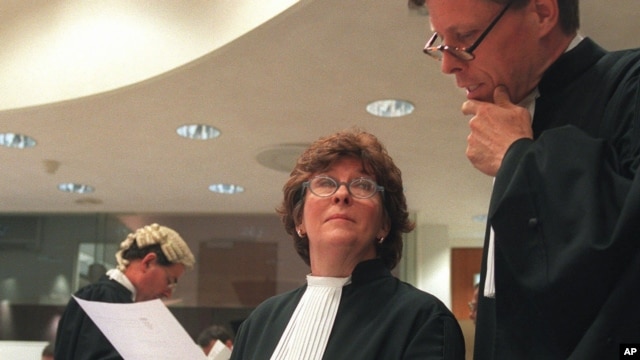 Prosecutor, Justice Louise Arbour, centre, talks to Mark Harmon, right, Senior Trial Attorney,  shortly before the beginning of the hearing at the International Criminal Tribunal for former Jugoslavia in The Hague, file photo. 
