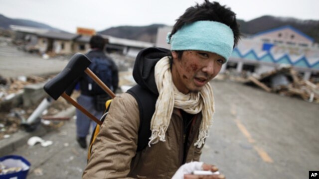 An injured survivor searches for food at a destroyed supermarket in the devastated residential area of Otsuchi, Japan, March 15, 2011.