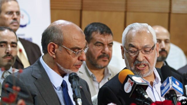 Rachid Ghannouchi (R), leader of the Islamist Ennahda party, speaks with his secretary-general Hamadi Jbeli (L) during a news conference in Tunis, October 28, 2011