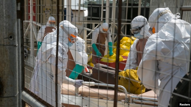 British health workers lift a newly admitted Ebola patient into a treatment center located outside of Freetown, Sierra Leone. (Dec. 22, 2014)
