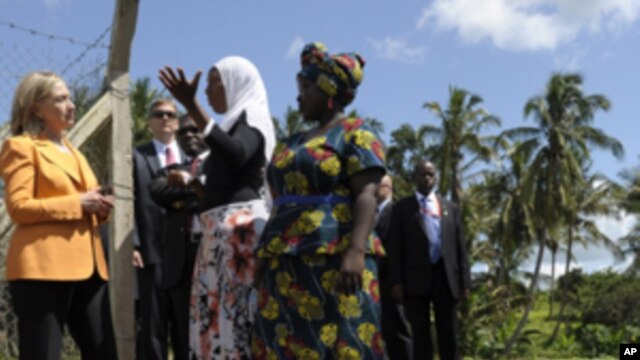 U.S. of State Hillary Rodham Clinton listens to with Halima Abubakary, white scarf, while talking with farmers of the Upendo Women's Cooperative in Mlandizi, Tanzania, Sunday, June 12, 2011.