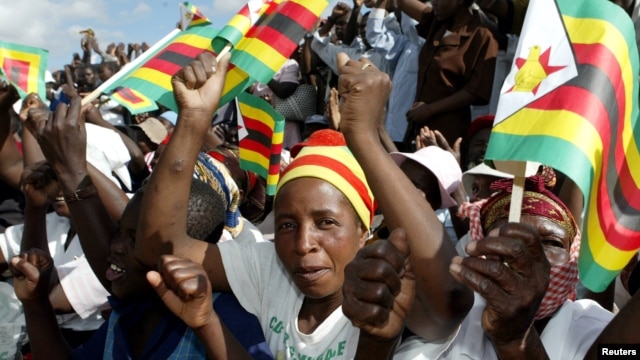FILE - Zimbabwe political supporters wave flags in Gutu, a rural town 220 Km's southeast of the capital Harare.
