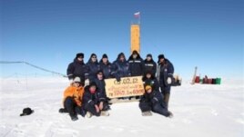 Russian researchers at the Vostok station in Antarctica after reaching subglacial Lake Vostok. Scientists hold a sign reading "05.02.12, Vostok station, boreshaft 5gr, lake at depth 3769.3 metres."