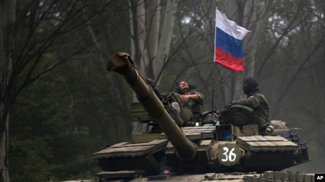 Một thành phần nổi dậy thân Nga ngồi trong chiếc xe tăng treo cờ Nga ở một con đường phía đông Donetsk, 21/7/2014.