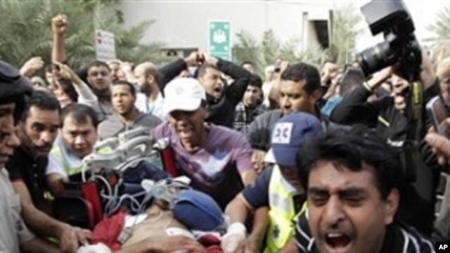 A Bahraini anti-government demonstrator lies injured on a stretcher as Bahraini anti-government demonstrators take him to hospital in Manama, Bahrain, early Thursday morning, Feb. 17, 2011