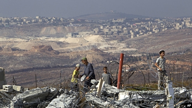 Jewish settler boys stand atop ruins of razed buildings in the unauthorized Jewish hilltop outpost of Migron, near the West Bank city of Ramallah, September 5, 2011.