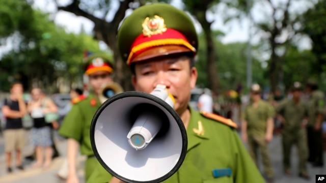 Ảnh minh hoạ: Cảnh sát Việt Nam dùng loa kêu gọi dân chúng và các nhà báo rời khỏi khu vực gần Đại sứ quán Trung Quốc tại Hà Nội, Việt Nam, ngày 18/5/2014.