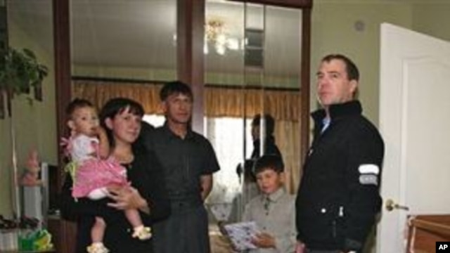 Russian President Dmitry Medvedev, right, visits an unidentified Russian family in the town of Yuzhnokurilsk, at the Pacific Island of Kunashir, Russia, 01 Nov 2010