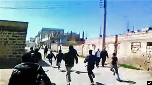 This image made from amateur video purports to show Syrian protesters running in Daraa, Syria, March 12, 2012.