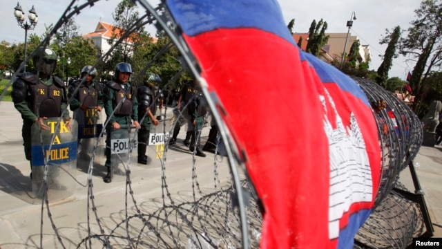 Police officers stand guard at Freedom Park during a protest in central Phnom Penh July 15, 2014.