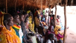 Refugees take shelter from the scorching sun as they wait to register at Yida refugee camp in South Sudan's Upper Nile, August 2012. (VOA - H. McNeish)