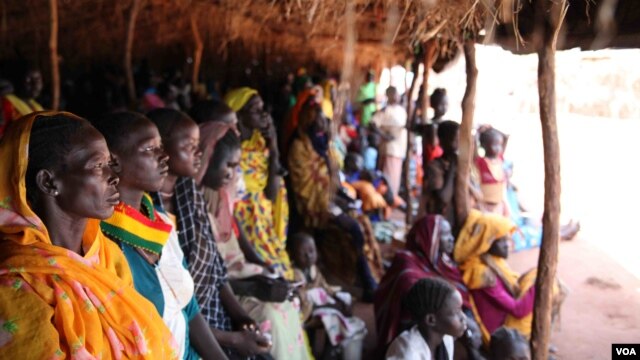 Refugees take shelter from the scorching sun as they wait to register at Yida refugee camp in South Sudan's Upper Nile, August 2012. (VOA - H. McNeish)
