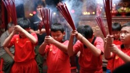 Indonesian ethnic Chinese children pray at a temple in the China Town in Jakarta, Indonesia, January 7, 2012. 