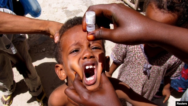 FILE - A health worker drops anti-polio vaccine into the mouth of a Somali child in Mogadishu September 10, 2006.