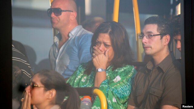 Familiares de los pasajeros del vuelo Malaysia Airlines MH-17 reaccionan al llegar al aeropuerto de Schiphol, en Ucrania.