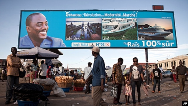 People walk under a giant poster showing Democratic Republic of the Congo 's President and candidate for a second term Joseph Kabila, in Kinshasa, November 7, 2011.