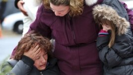 Mourners grieve at one of the makeshift memorials for victims of the Sandy Hook Elementary School shooting, Dec. 16, 2012, in Newtown, Conn.