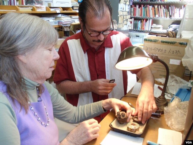 Donor Steven Martin and University of Idaho curator Priscilla Wegars examine and catalogue the donated opium artifacts.(VOA/T. Banse)