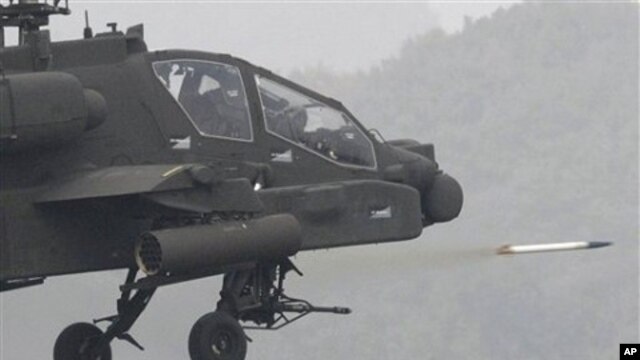 US Apache helicopter fires rocket during joint military exercise between South Korea and United States at US firing Rodriguez Range in Pocheon, south of the demilitarized zone that divides two Koreas, 13 Oct. 2010.