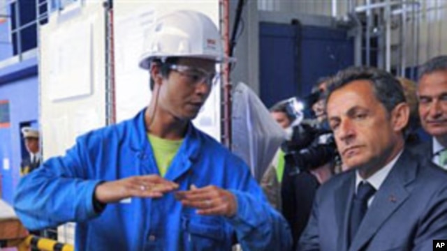 France's President Nicolas Sarkozy, right, listen to a worker during a visit at the Saint Nazaire naval plant, in Saint Nazaire, western France (File)