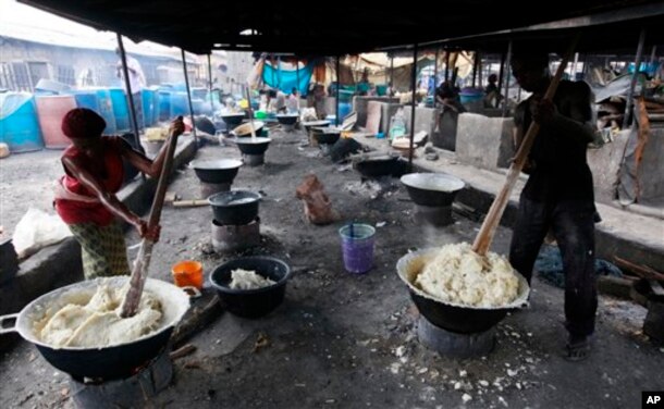 FILE: People prepare food made from cassava flour in a market in Nigeria.