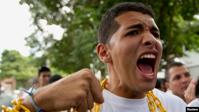 Estudiantes venezolanos rezan mientras se encadenas durante una protesta frente a la embajada de Cuba.