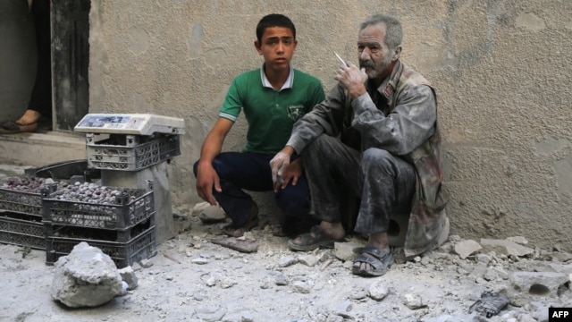 A man covered with dust sits on a street following a reported airstrike by Syrian government forces in the rebel-held neighborhood of Sukkari in the northern city of Aleppo, May 30, 2016.