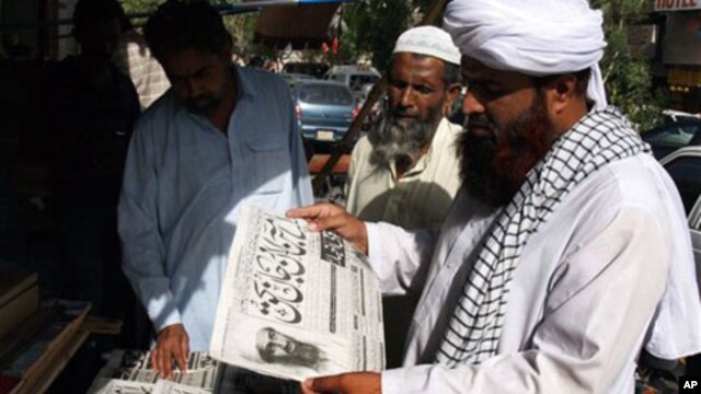 People read newspapers at a news stand carry headlines "Osama bin Laden killed." in Hyderabad, Pakistan on Monday, May 2, 2011.