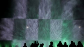 People are silhouetted as they watch a night fountain show with color lights near the Centennial  Hall in Wroclaw, Poland, Thursday, Oct. 7, 2010.(AP Photo/Alik Keplicz)