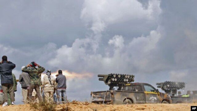 National Transitional Council fighters fire a rocket during clashes with pro-Gadhafi forces at the frontline in Sirte, Libya, October 11, 2011.