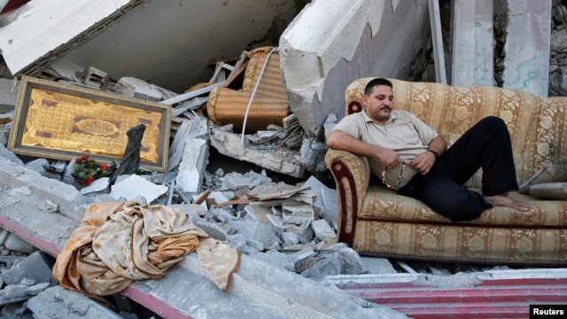 Người Palestine nằm giữa đống đổ nát của căn nhà bị phá hủy trong khu phố Shejaia sau các vụ pháo kích của Israel vào thành phố Gaza.