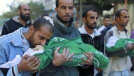 A Palestinian man kisses the body of one of his children during their funeral in the northern Gaza Strip, November 18, 2012. (Reuters)