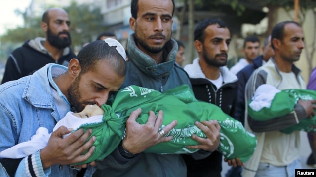 A Palestinian man kisses the body of one of his children during their funeral in the northern Gaza Strip, November 18, 2012. (Reuters)