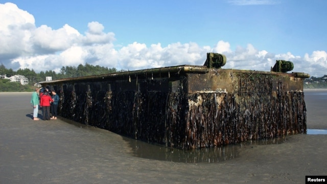 Oregon Parks and Recreation Department photograph shows a very large and heavy dock that washed ashore on Agate Beach, north of Newport, Oregon on June 6, 2012. 